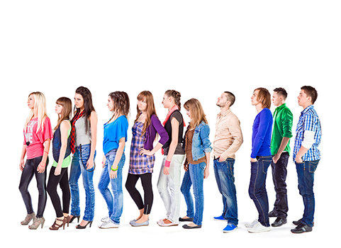 Large groupe of young adult people standing in a row and waiting for something. Studio shot on the white background.